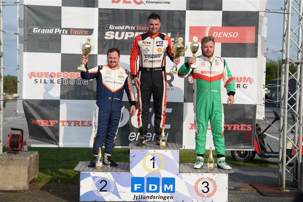 Tre glade herrer ved GP Danmark på FDM Jyllandsringen. Frederik Nymark (t.v.) udbyggede sin mesterskabsførring. Casper Pilgaard (i midten) tog sin første finalesejr i tre år. Steffen Petersen (t.h.) kom på podiet i sit første Super GT-løb på FDM Jyllandsringen.
(Foto: Stumpphoto)